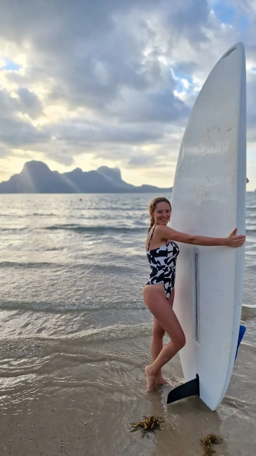 Patricia Rusu cu o placă de surf pe plajă